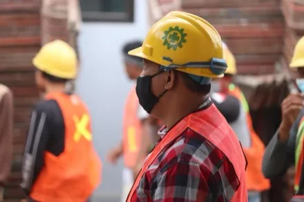 Cuadrilla con casco y chaleco reflectante en obra